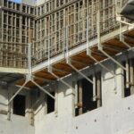 Plataforma metálica de sistema de segurança manoportátil com guarda-corpo instalada em estrutura de concreto.